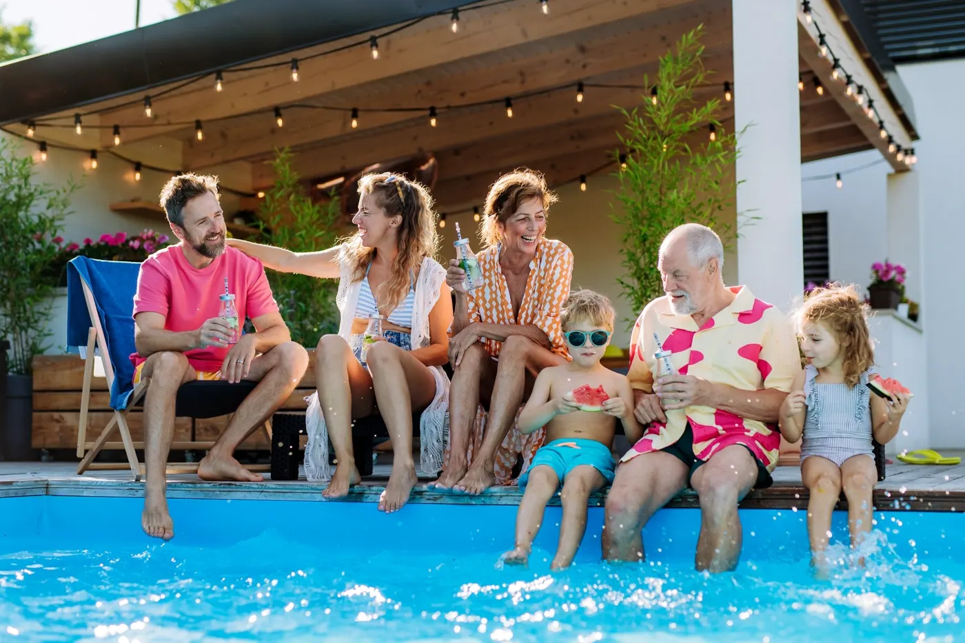 Family relaxing beside a clean inground pool in a Tucson backyard
