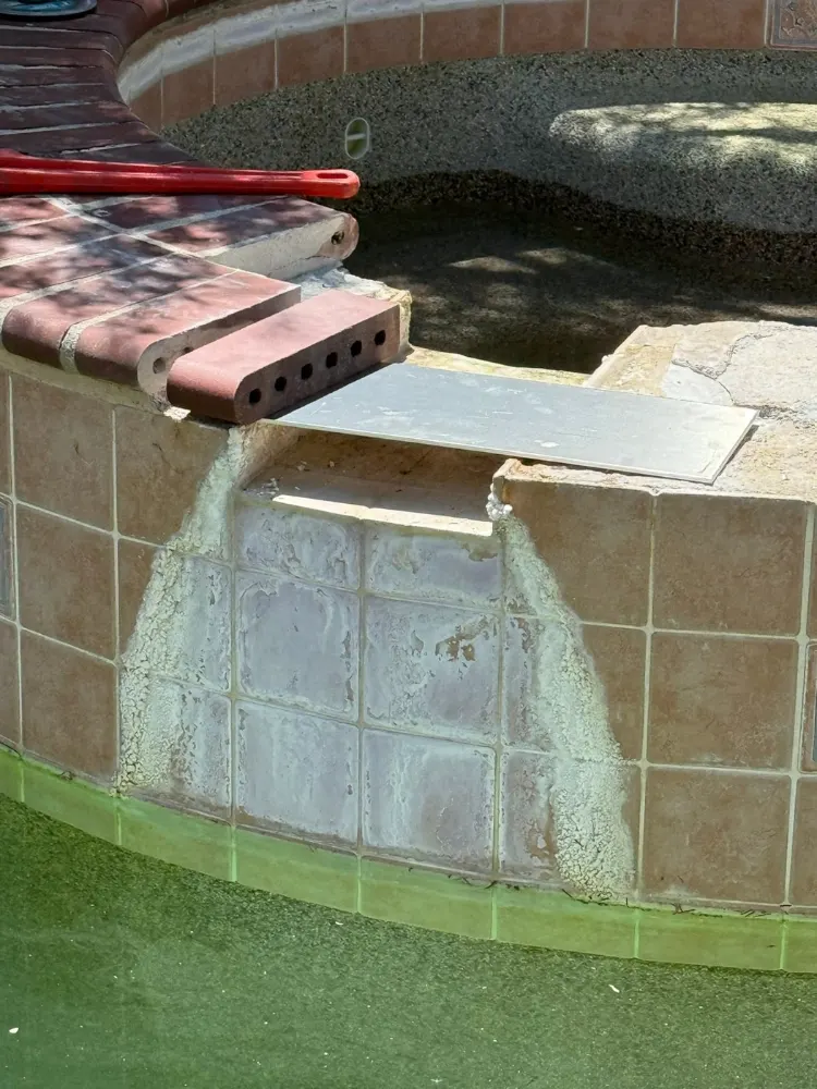Stained spa spillway tile before cleaning in Tucson